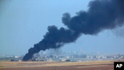 In this photo taken from the Turkish side of the border between Turkey and Syria, in Akcakale, Sanliurfa province, southeastern Turkey, smoke billows from a fire inside Syria during bombardment by Turkish forces, Oct. 9, 2019. 