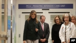 First lady Melania Trump, left, accompanied by U.S. Secretary of Health and Human Services Alex Azar, walks with staff during a visit to Boston Medical Center, in Boston, Massachusetts, Nov. 6, 2019. 