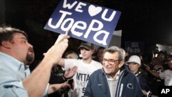 FILE - Scott Paterno (L) looks on as students greet his father, Penn State football coach Joe Paterno, as he arrives at his home in State College, Pa., Nov. 8, 2011. 
