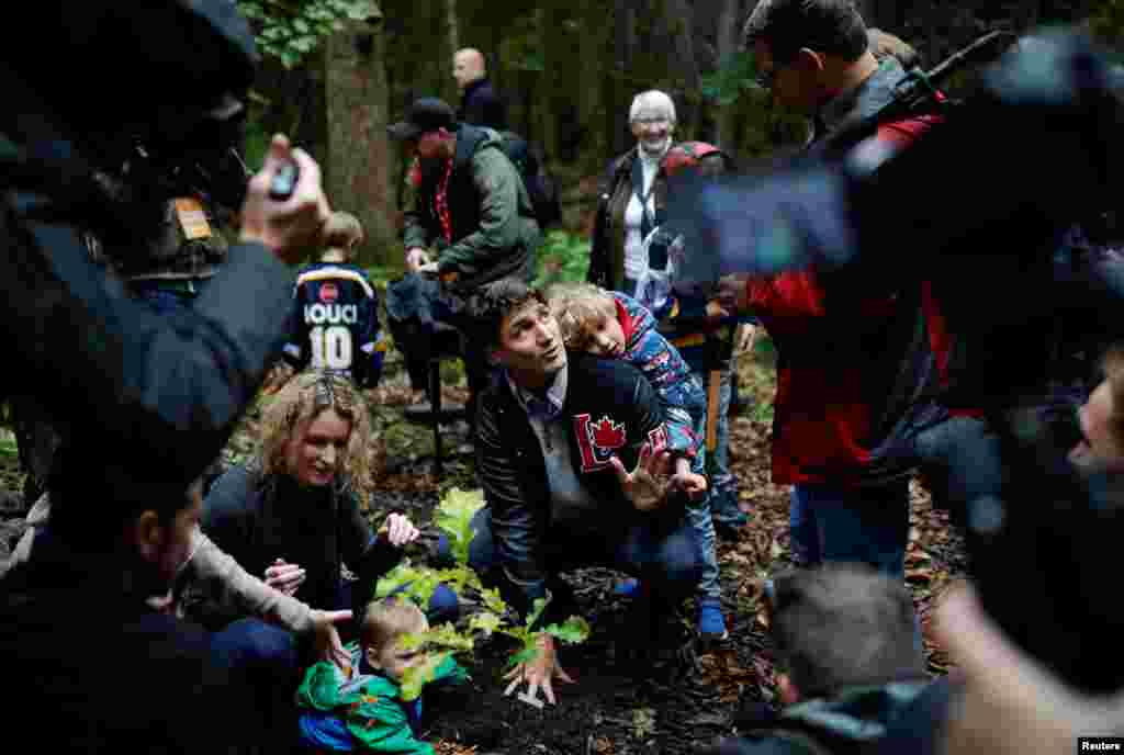 Canadian Prime Minister Justin Trudeau attends a tree planting with his son Hadrien during an election campaign visit to Plainfield, Ontario, Oct. 6, 2019.