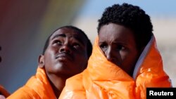 Des migrants attendent en ligne dans un bateau au port de Pozzallo, en Italie, le 29 mars 2016.