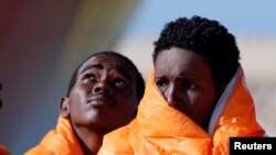 Des migrants attendent en ligne dans un bateau au port de Pozzallo, en Italie, le 29 mars 2016.