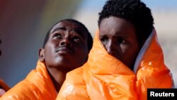 Des migrants attendent en ligne dans un bateau au port de Pozzallo, en Italie, le 29 mars 2016.