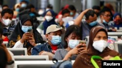 Penumpang duduk di stasiun kereta sambil menunggu untuk kembali ke kampung halaman menjelang perayaan Idul Fitri atau "mudik", di tengah pandemi COVID-19, di Jakarta, 5 Mei 2021. (Foto: Reuters)