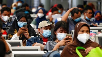 Penumpang duduk di stasiun kereta sambil menunggu untuk kembali ke kampung halaman menjelang perayaan Idul Fitri atau "mudik", di tengah pandemi COVID-19, di Jakarta, 5 Mei 2021. (Foto: Reuters)