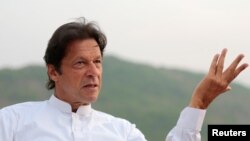 FILE - Pakistani opposition politician Imran Khan speaks with party leaders at his home in Bani Gala, outside Islamabad, Pakistan, Oct. 30, 2016. India said Friday that recent "brutal killings" revealed the "true face" of the country's new prime minister.