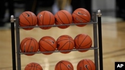 FILE - Basketballs sit in a rack during a game in Boulder, Colo., Jan. 23, 2020.