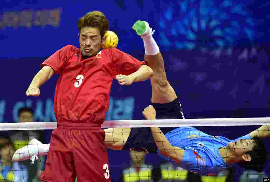 Japan's Takeshi Terashima (L) tries to block the ball against South Korea's Kim Young-Man (R) in the men's team sepaktakraw preliminary match during the 2014 Asian Games at Bucheon Gymnasium in Bucheon, east of Incheon, South Korea.