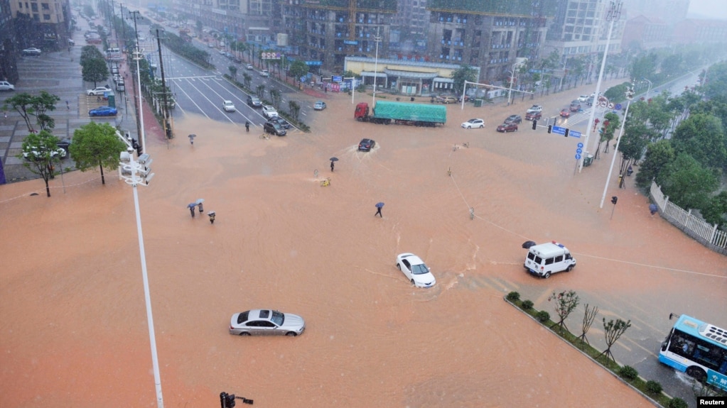 湖南长沙，大路积水，行人和车辆冒雨过马路（2017年7月1日）