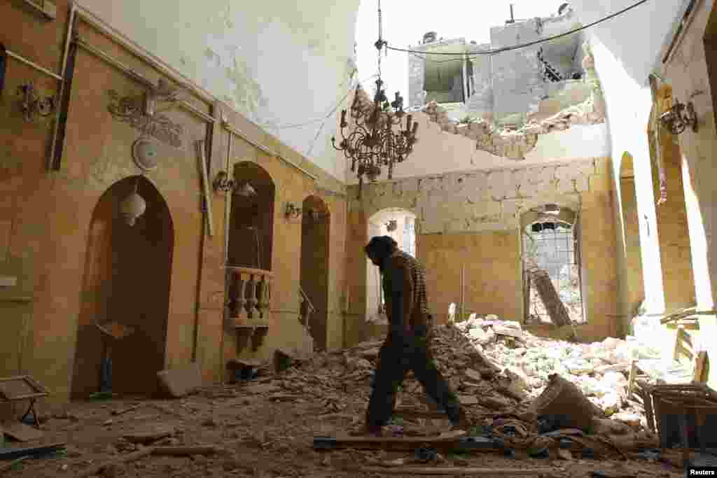 A man walks inside a mosque damaged by what activists described as a barrel bomb attack by forces loyal to President Bashar Al-Assad in Aleppo, May 1, 2014.