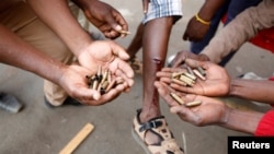 FILE: Opposition Movement for Democratic Change supporters hold spent rounds and show injuries after soldiers opened fire outside the party's headquarters in Harare, Zimbabwe, Aug. 1, 2018.