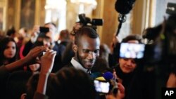 Lassana Bathily, tengah, imigran Mali dan seorang pekerja toko kelontong halal di Paris yang diserang seorang pria bersenjata yang menyelamatkan beberapa orang Yahudi yang sedang berbelanja minggu lalu, berbicara dengan anak-anak di Balai Kota Paris, Perancis, 16 Januari 2015.