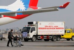 A van stands parked waiting to transport AstraZeneca/Oxford University vaccines, manufactured under license by Serum Institute of India, at Tribhuwan International Airport in Kathmandu, Nepal, Thursday, Jan. 21, 2021.