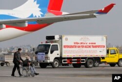 A van stands parked waiting to transport AstraZeneca/Oxford University vaccines, manufactured under license by Serum Institute of India, at Tribhuwan International Airport in Kathmandu, Nepal, Thursday, Jan. 21, 2021.