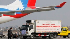A van stands parked waiting to transport AstraZeneca/Oxford University vaccines, manufactured under license by Serum Institute of India, at Tribhuwan International Airport in Kathmandu, Nepal, Thursday, Jan. 21, 2021.