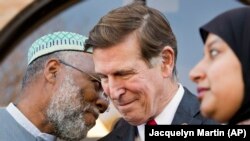 FILE - U.S. Rep. Don Beyer, center, meets with imam Johari Abdul-Malik, left, and others at Dar al-Hijrah Mosque in Falls Church, Va., Dec. 4, 2015. The Virginia Democrat is pressing Cairo to release Egyptian-American Aya Hijazi.