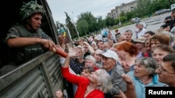 FILE - People receive food aid in Slovyansk, Ukraine, in 2014. The proportion of people donating money in Ukraine quadrupled in 2014 compared to the previous year.