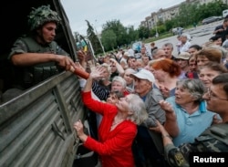 People receive food aid from Ukrainian soldiers in Slovyansk, Ukraine, July 6, 2014.