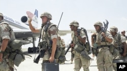 Des membres du 3e bataillon du 9e régiment américain embarquent à bord de leur à destination de l'aéroport de Mogadiscio, Somalie, 19 janvier 1993. 