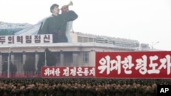 2012年12月14日,朝鮮軍隊高舉標語在平壤的金日成廣場舉行慶祝朝鮮成功發射衛星的遊行(從左到右的標語:革命精神,偉大領袖金正恩同志,偉大領袖)