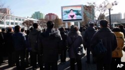 29일 평양 기차역에서 북한 주민들이 화성-15 미사일 발사에 관한 정부 성명을 대형스크린으로 시청하고 있다.