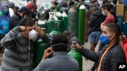 Habitants de Callao au Pérou dans l'attente de remplir leurs bouteilles d’oxygène, le 3 juin 2020. Les hôpitaux signalent des pénuries d’oxygène face à la pandémie de COVID-19. (AP Photo/Martin Mejia)