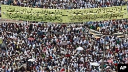 Protesters gather with a banner with a Koranic verse in Tahrir square in Cairo, July 29, 2011