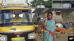 In this photo provided by Singing River International Ministries, Shobha Chothe of Ahmednagar, India, poses next to a new cab she purchased after applying for a small business loan from Singing River Internaional Ministries (FILE).