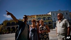 FILE - Tour guide Javier Rodriguez, left, speaks to tourists in Havana, Cuba, Jan. 18, 2018.