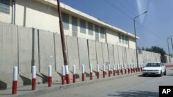 A car passes American University of Afghanistan in Kabul, Afghanistan, Monday, Aug. 8, 2016.