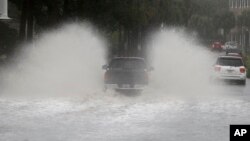 A driver takes his truck through a flooded street in Charleston, S.C., Oct. 3, 2015. 