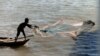 A fisherman throws a net along the banks of the Mekong River, in Phnom Penh, Cambodia, Dec. 22, 2014.