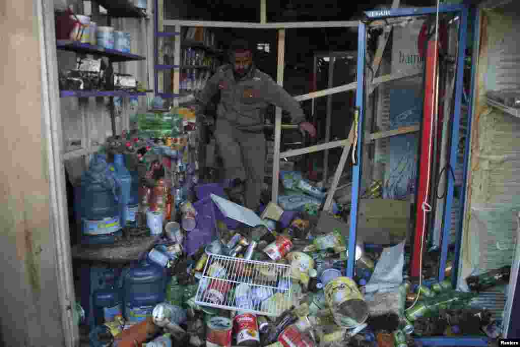 Seorang pria memeriksa kerusakan akibat serangan bom, di distrik Ur timur laut Baghdad, 18 Februari 2014.&nbsp;