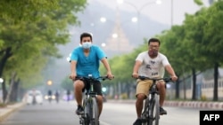 နှာခေါင်းစည်းတပ်ထားပြီး စက်ဘီးစီးသူတချို့ကို မန္တလေးမြို့မှာတွေ့ရ။ (ဧပြီ ၀၇၊ ၂၀၂၀)