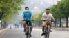 မန္တလေးမြို့မှာ နှာခေါင်းစည်းများတပ်ထားပြီး စက်ဘီးစီးနေကြတဲ့ အမျိုးသားနှစ်ဦး (ဧပြီ ၀၇၊ ၂၀၂၀)
