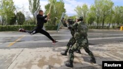 FILE - Border police take part in an anti-terrorism drill near Baketu border in Tacheng, Xinjiang Uighur Autonomous Region, China, April 28, 2016.