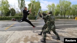 FILE - Border police take part in an anti-terrorism drill near Baketu border in Tacheng, Xinjiang Uighur Autonomous Region, China, April 28, 2016.