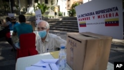 En la foto de archivo un voluntario espera a los votantes durante una consulta organizada por la oposición para rechazar el gobierno del presidente Nicolás Maduro en Caracas, Venezuela, el sábado 12 de diciembre de 2020.