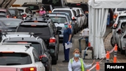 Vehicles queue while medical personnel administer tests for the coronavirus disease (COVID-19) at the Bondi Beach drive-through testing centre as the city experiences an outbreak in Sydney, Australia, Dec. 21, 2020. 