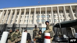 Fuerzas antigubernamentales hacen guardia frente al Banco Central de Siria en Damasco, el 9 de diciembre de 2024.