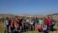 American rabbinical students take a group photo, with the village of Attuwani in the background, during a day planting olive trees, near Hebron in the West Bank, Jan. 25, 2019. In a departure from past programs that focused on strengthening ties with Israel, the new crop of students is also reaching out to the Palestinians. 