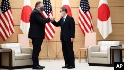 Japan's Prime Minister Yoshihide Suga, right, and U.S. Secretary of State Mike Pompeo pose as they attend a meeting at the prime minister's office in Tokyo Tuesday, Oct. 6, 2020, ahead of the four Indo-Pacific nations' foreign ministers meeting. …