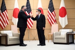 Japan's Prime Minister Yoshihide Suga, right, and U.S. Secretary of State Mike Pompeo greet at the prime minister's office in Tokyo, Oct. 6, 2020, ahead of the four Indo-Pacific nations' foreign ministers meeting.