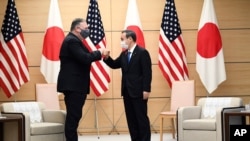 Japan's Prime Minister Yoshihide Suga, right, and U.S. Secretary of State Mike Pompeo pose as they attend a meeting at the prime minister's office in Tokyo Tuesday, Oct. 6, 2020, ahead of the four Indo-Pacific nations' foreign ministers meeting. …