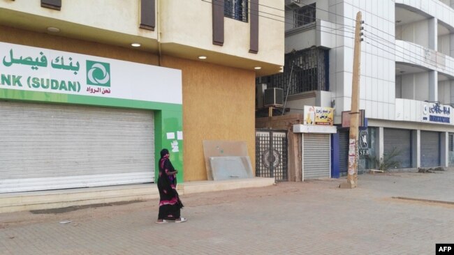 A woman walks past two closed banks in a deserted street in Sudan's capital Khartoum, Sudan, June 4, 2019.