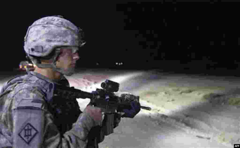 CORRECTS DATE TO FRIDAY - In this Friday, Dec. 16, 2011 photo, Sergeant Daniel Martin of the 3rd Brigade Combat Team, 1st Cavalry Division protects the perimeter outside his unit's Mine Resistant Ambush Protected (MRAP) vehicle during the U.S. military's 