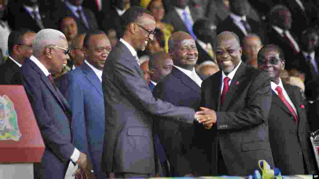 Le nouveau président de la Tanzanie John Pombe Magufuli (centre-droite) est félicité par le président du Rwanda Paul Kagame (centre-gauche) avec à l’arrière leurs homologues Uhuru Kenyatta du Kenya (centre-gauche), Yoweri Museveni de l’Ouganda (centre) et Robert Mugabe du Zimbabwe (droite) au cours de la cérémonie de prestation de serment au stade Uhuru à Dar es Salam, 5 novembre 2015. (AP Photo/Khalfan Said)