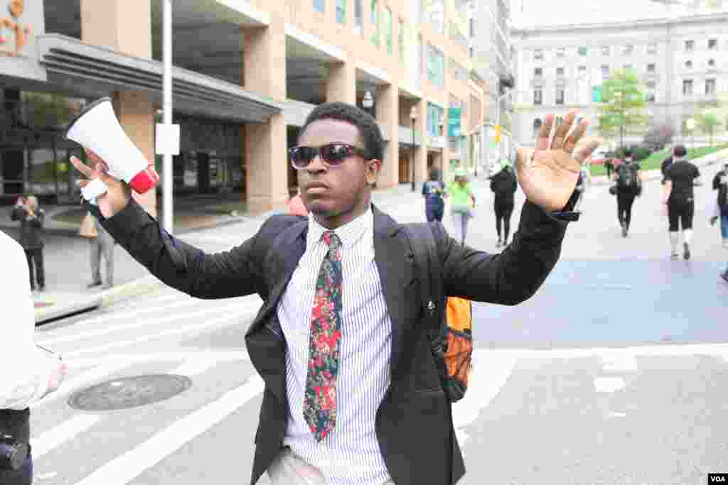 A student holds his hands up symbolically in a massive march against police brutality and discrimination. April 30, 2015. (Victoria Macchi/VOA News)