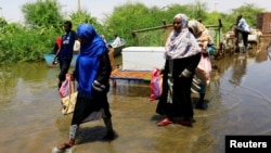 Des personnes pataugent dans les eaux de crue près du Nil, dans la banlieue de Khartoum, au Soudan, le 2 septembre 2019.