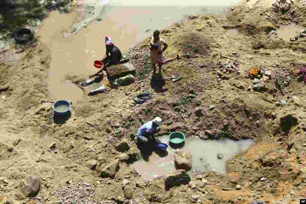 Small-scale miners are seen on a river bed in the outer part of Harare, Zimbabwe. The country&#39;s government says it has banned mining in its national parks.